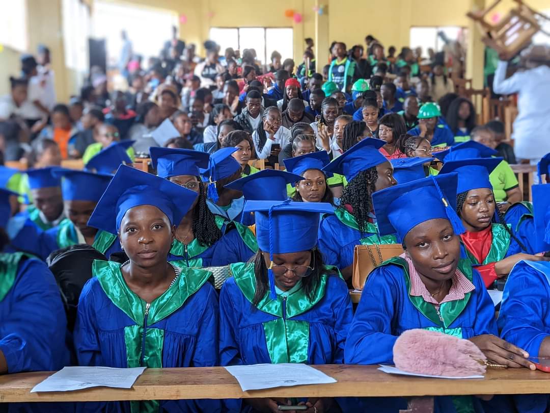 Rangées de diplômés en toge attendant la remise des parchemins.